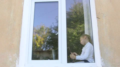 Cute child sitting on the window immersed in game with digital tablet Stock-Footage 43348987