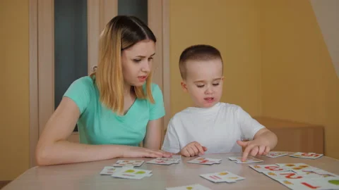 Cute child studying with his young mother, playing educational card game Video stock 175452345