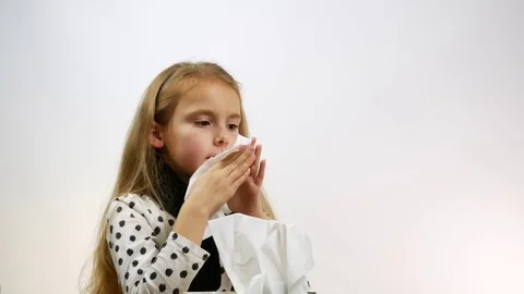 Cute child suffering from rhinitis blows her nose, a studio shot. Stock Footage 83762759