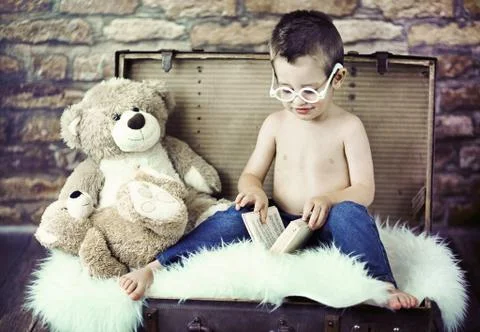 Cute child trying to read Stock Photos