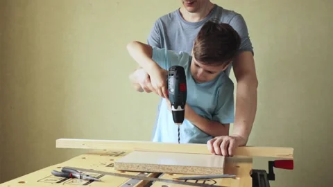 Cute child using drill screwdriver and father helping him Stock Footage 158647251