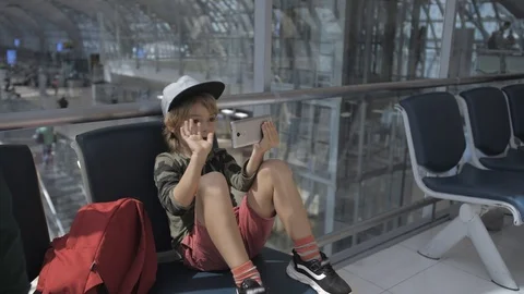 Cute child video chats on smart phone in airport before departure. Stock-Footage 104016644