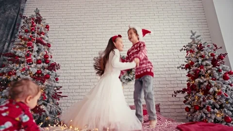 Cute children jumping on bed with pillow, christmas morning time, kids party Stock Footage 166629238