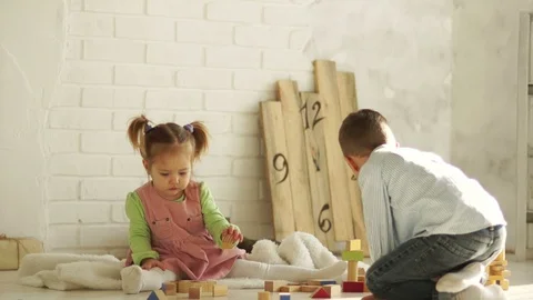 Cute children learning to stack toy blocks together. Brother runs away Stock Footage 87077165