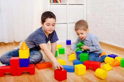 Cute children playing with constructor on floor at home Foto stock
