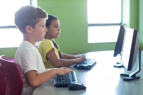 Cute children using computers in classroom Stock Photos