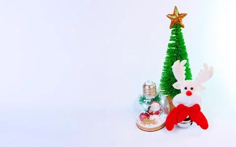 Cute Christmas background featuring a soft reindeer toy and miniature Christmas Stock Photos