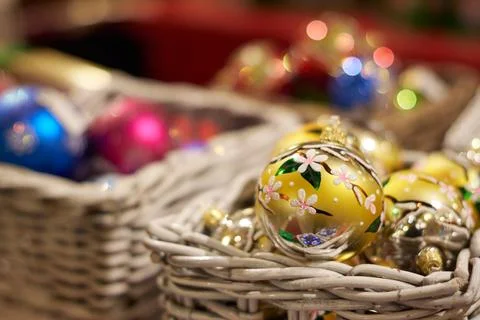 Cute Christmas ball toys lie in a wicker basket. Christmas Fair. Selective fo Stock Photos