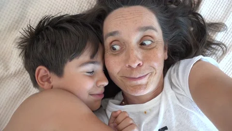 Cute comic boy pretends sleeping when mother making selfie Stock Footage 202067313