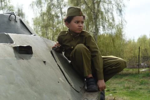 Cute cool boy in costume of the Second World War time sitting in the tank Stock Photos