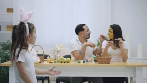 Cute couple is colorizing each other with a help of Easter paint-brush, on the Video stock 104915892