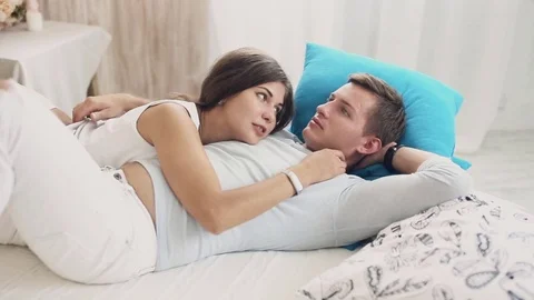 Cute couple cuddling and talking on bed Stock Footage 70512126