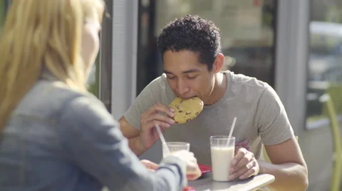 Cute Couple On A Date, Young Man Takes A Bite, Then Dunks Cookie In Milk (4K) Stock Footage 51636211