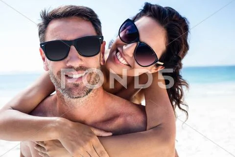 Cute Couple Hugging With Arms Around On The Beach