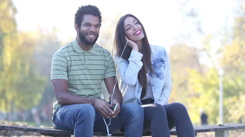 Cute couple listening to music together, sharing earphones Stock Footage 59555743