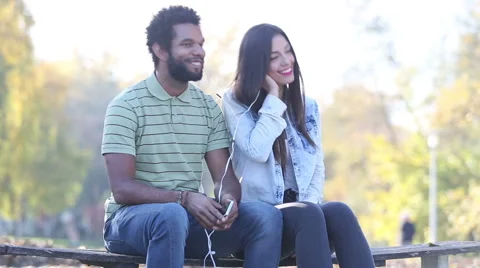 Cute couple listening to music together, sharing earphones Stock Footage 59555746