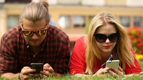 Cute couple lying on the grass in the park and relaxing Stock Footage 77482400