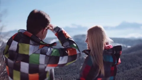 Cute couple in multicolored ski suits standing on the observation deck Stock Footage 71781414