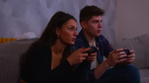 Cute couple playing video games intensly both of them lose the game and fall Stock Footage 292104732