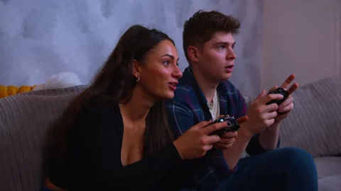 Cute couple playing video games intensly both of them win and celebrate toge Stock Footage 292104972