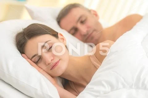 The cute couple sleeping on the bed Stock Photos