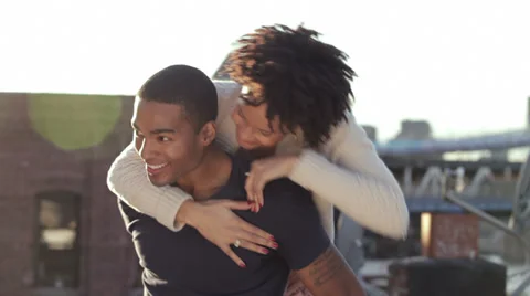 A cute couple spend time together on a rooftop in the city Stock Footage 33999076