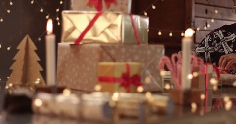 Cute couple in winter sweaters wrapping Christmas presents Stock Footage 81916374