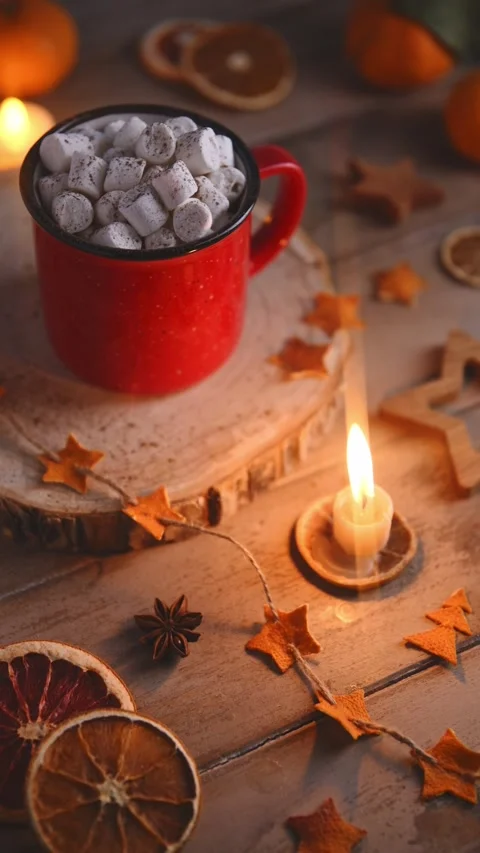 Cute cozy winter composition. red mug, marshmallows, oranges and candle. Stock Footage 259048973
