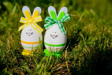Cute creative photo with easter eggs as the Easter Bunny on green grass Stock Photos