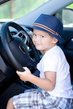 Cute driver in blue hat sits in car Foto stock