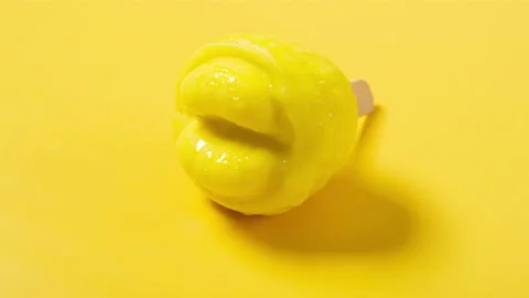 Cute durian meat shape and flavor popsicle melting timelapse on yellow backgr Stock Footage 208818892
