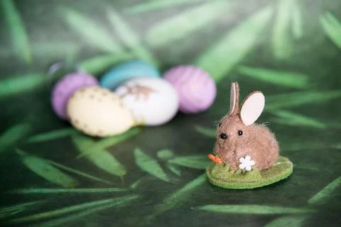 Cute easter bunny and colored eggs, green background Stock Photos