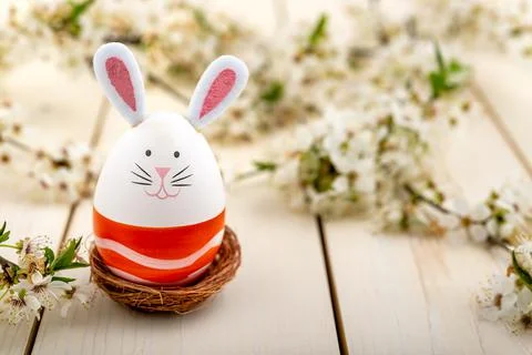 Cute Easter bunny and a plum flowers on wooden background Stock Photos