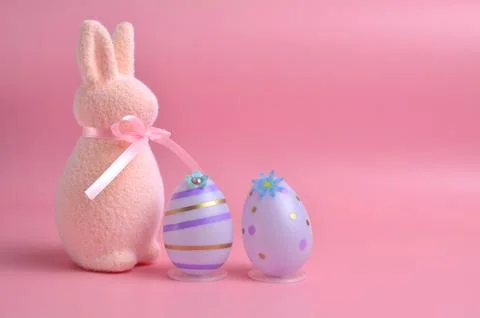 Cute Easter bunny on a purple background and purple eggs. Easter. Stock Photos