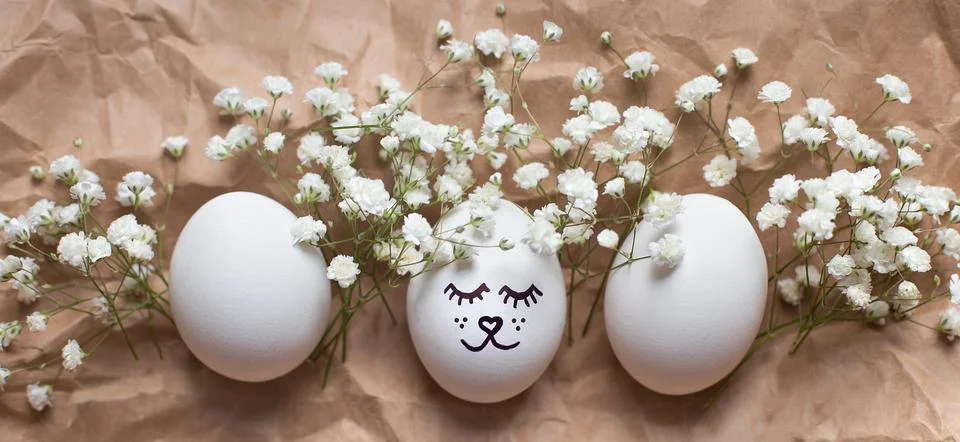 Cute easter egg with drawn face. Gypsophila flowers Foto stock
