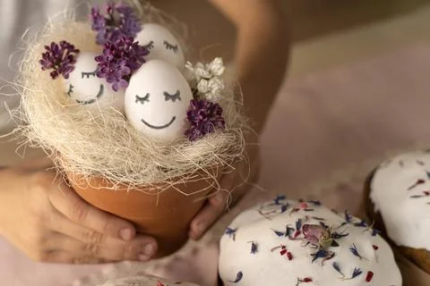 Cute Easter eggs with painted smiley faces and lilac flowers. Celebration. Funny Stock-Fotos
