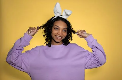 Cute easter portrait with happy smiling sfrican american girl in eater bunny Stock Photos