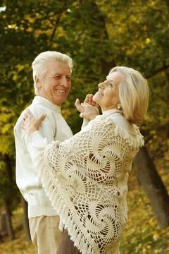Cute elderly couple dancing in a fall park Stock Photos