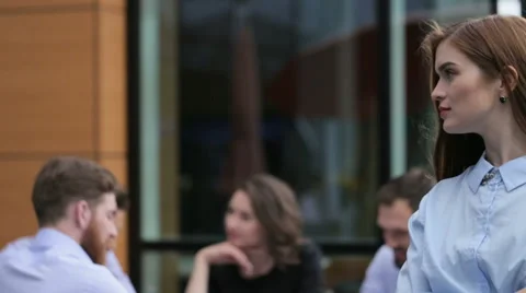 Cute emplyee posing on camera , while her colleagues working in the office Stock Footage 64114083