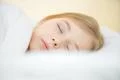 The cute face of the young girl on the pillow Photo