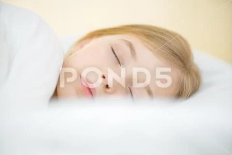 The cute face of the young girl on the pillow Stock Photos