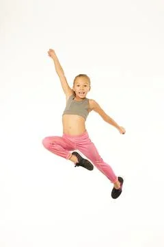 Cute female child in sportswear jumping in studio Stock Photos