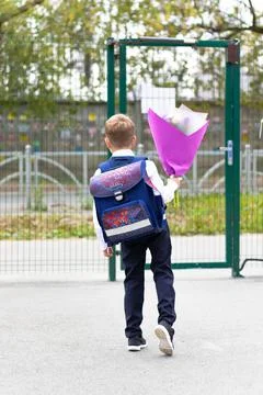 A cute first-grader boy in a school uniform with a beautiful bouquet of color Stock Photos
