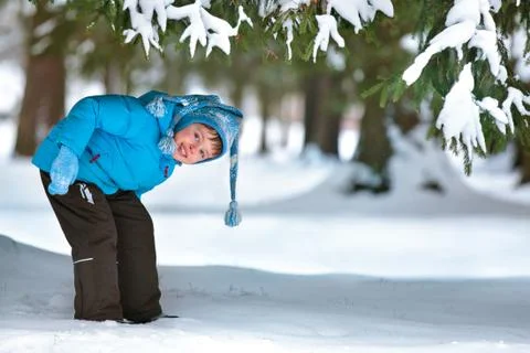 Cute five years old boy playing on winter forest Foto stock
