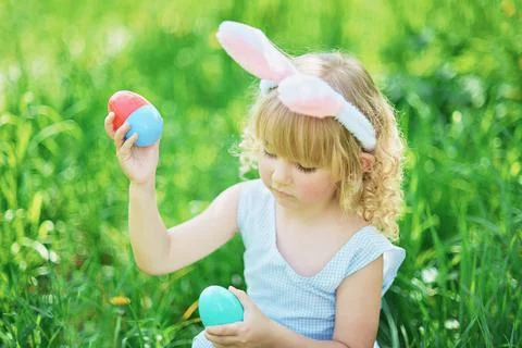 Cute funny girl with Easter eggs and bunny ears at garden. easter concept. La Foto stock