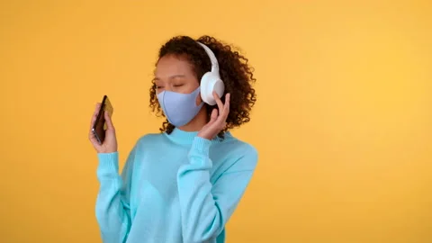 Cute funny lady with afro dancing on an isolated yellow background she is in her Stock Footage 141858754