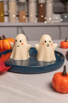 Cute ghost-shaped marshmallow desserts on blue plate with mini pumpkins Stock Photos