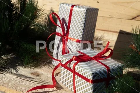 Cute gifts with red ribbon near christmas tree Stock Photos