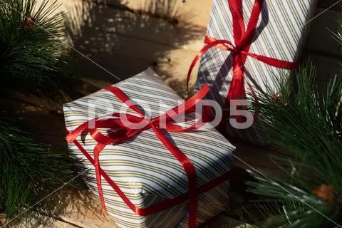 Cute gifts with red ribbon near christmas tree Stock Photos