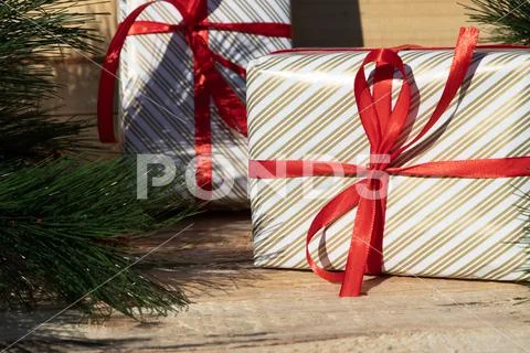 Cute gifts with red ribbon near christmas tree Stock Photos